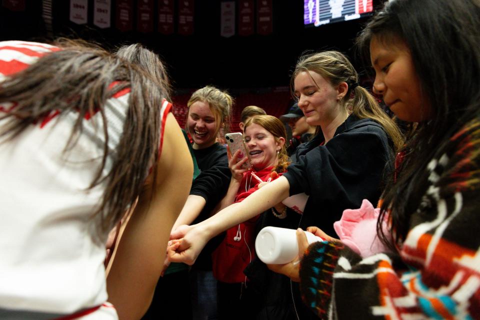 Utah Utes forward Jenna Johnson (22) signs the wrists of a group of fans after the Utah Utes’ victory in their women’s college basketball game against Weber State University at the Jon M. Huntsman Center in Salt Lake City on Thursday, Dec. 21, 2023. | Megan Nielsen, Deseret News