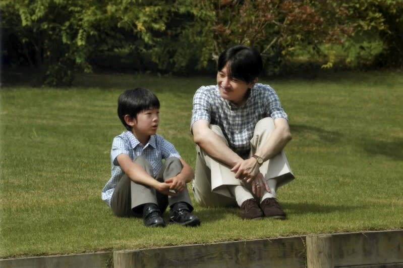 FILE PHOTO: Japan's Prince Hisahito and his father Prince Akishino talk as they sit on the grounds of the Akasaka Detached Palace in Tokyo