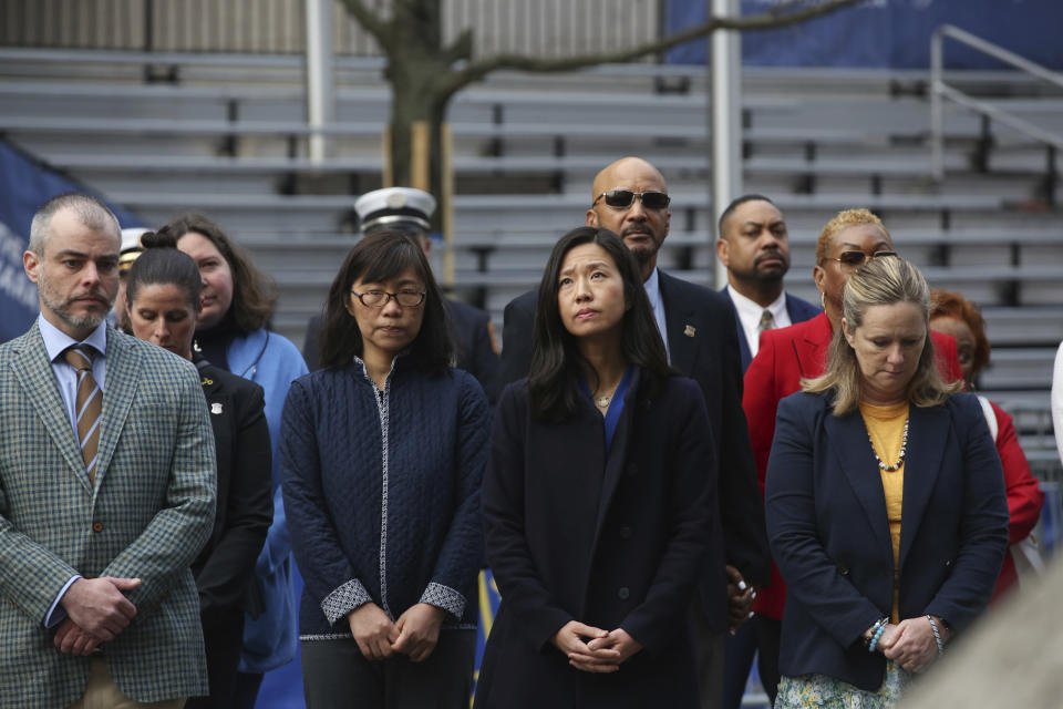 CORRECTS TO THIRD LEFT - Boston Mayor Michelle Wu, third from left, participates in a moment of silence during a gathering at a memorial for victims of the 2013 Boston Marathon bombing, Saturday April 15, 2023, in Boston. (AP Photo/Reba Saldanha)