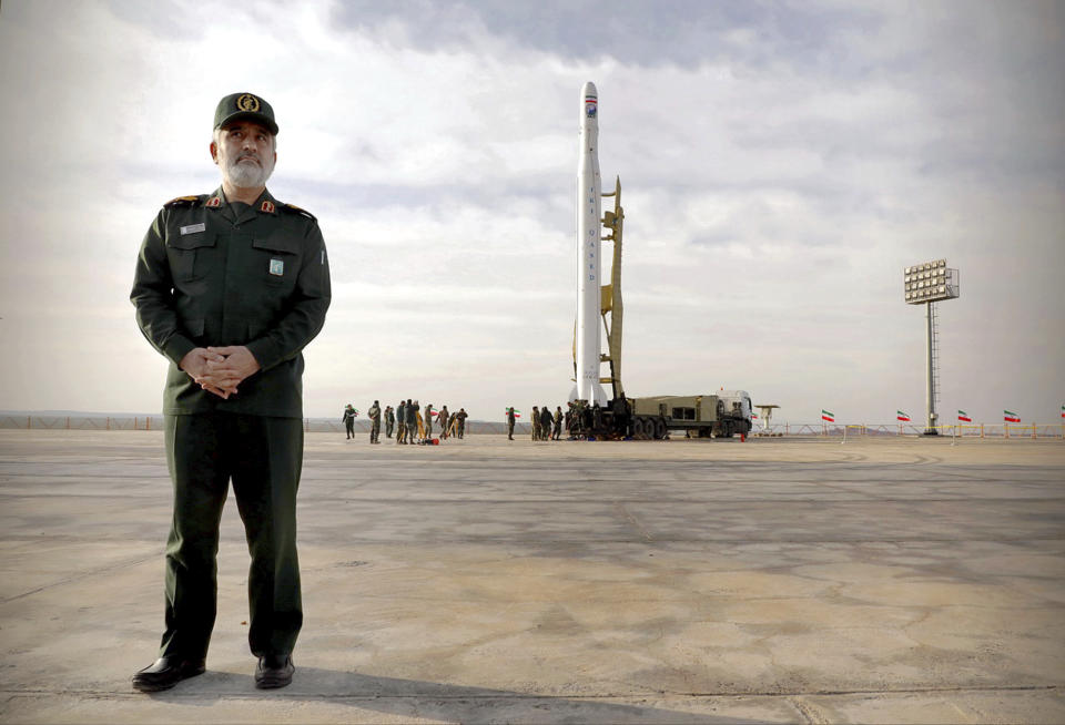 In this photo released Wednesday, April 22, 2020, by Sepahnews, Gen. Amir Ali Hajizadeh, the head of the Revolutionary Guard's aerospace division stands in front of an Iranian rocket carrying a satellite in an undisclosed site believed to be in Iran's Semnan province. The Guard said Wednesday it put the Islamic Republic's first military satellite into orbit, dramatically unveiling what experts described as a secret space program with a surprise launch that came amid wider tensions with the United States. (Sepahnews via AP)