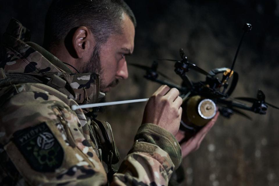 A Ukrainian military pilot of a FPV drone while he attaches an explosive to an FPV drone at the frontline near Bakhmut on October 24, 2023, in Bakhmut, Ukraine.