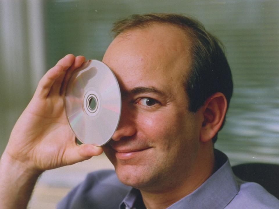 Jeff Bezos hold CD up to his eye