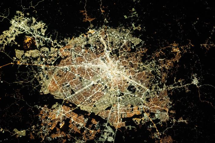 ville circulaire éclairée la nuit vue depuis l'espace