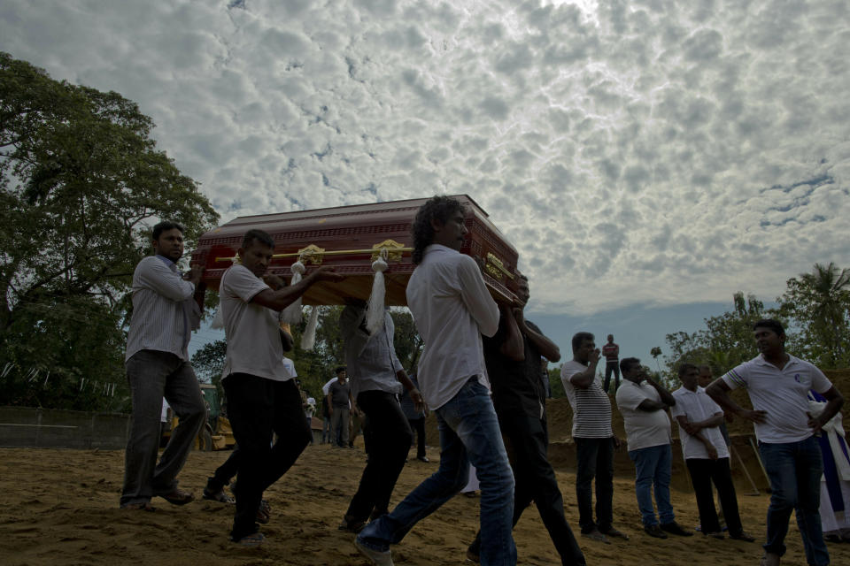 Relatives carry a coffin for burial during a mass burial for Easter Sunday bomb blast victims in Negombo, Sri Lanka, Wednesday, April 24, 2019. (AP Photo/Gemunu Amarasinghe)