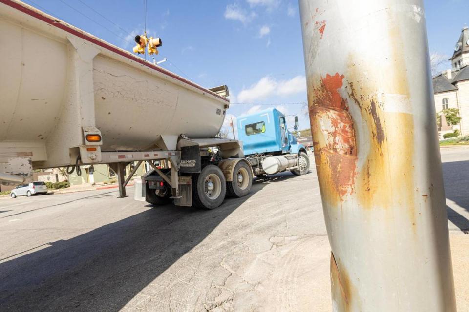 A semi truck attempts to make a right turn next to a damaged light pole from a truck turning too narrowly on NE Barnard Street in Glen Rose on Wednesday, March 13, 2024. Glen Rose officials have been proposing a detour to TxDOT and local quarries to keep trucks out of it’s downtown, however they’ve been unsuccessful and an influx of visitors for spring break has worsened the traffic problems.