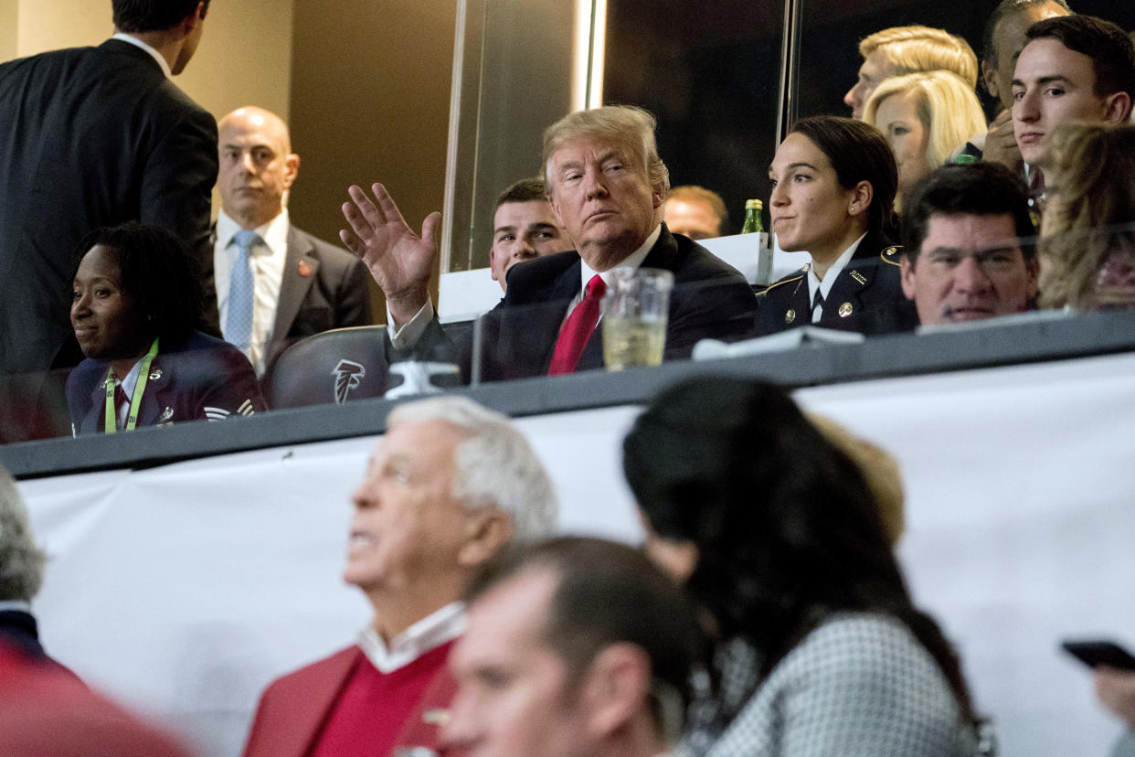 President Donald Trump waves to members of the media while watching the NCAA National Championship game at Mercedes-Benz Stadium, Monday, Jan. 8, 2018, in Atlanta, between Alabama and Georgia. (AP Photo/Andrew Harnik)