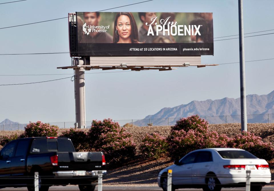 A 2009 University of Phoenix billboard is shown in Chandler, Ariz. The for-profit college and its parent company had to pay $50 million and cancel $141 million in student debt to settle allegations of deceptive advertisement brought by the Federal Trade Commission.