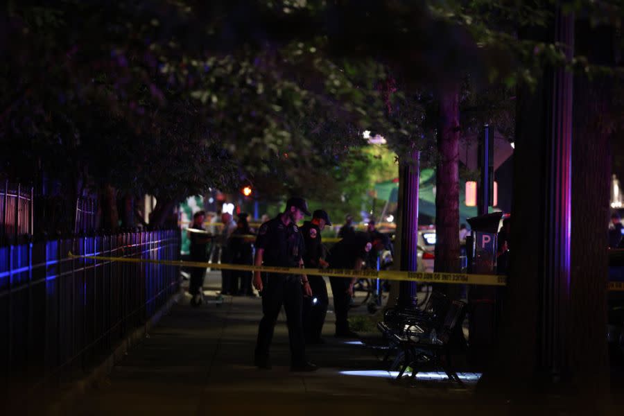 Police investigate a shooting on July 22, 2021, in Washington. Gunfire erupted on a busy street, injuring two people and sending others fleeing for safety. (Photo credit: Anna Moneymaker/Getty Images)