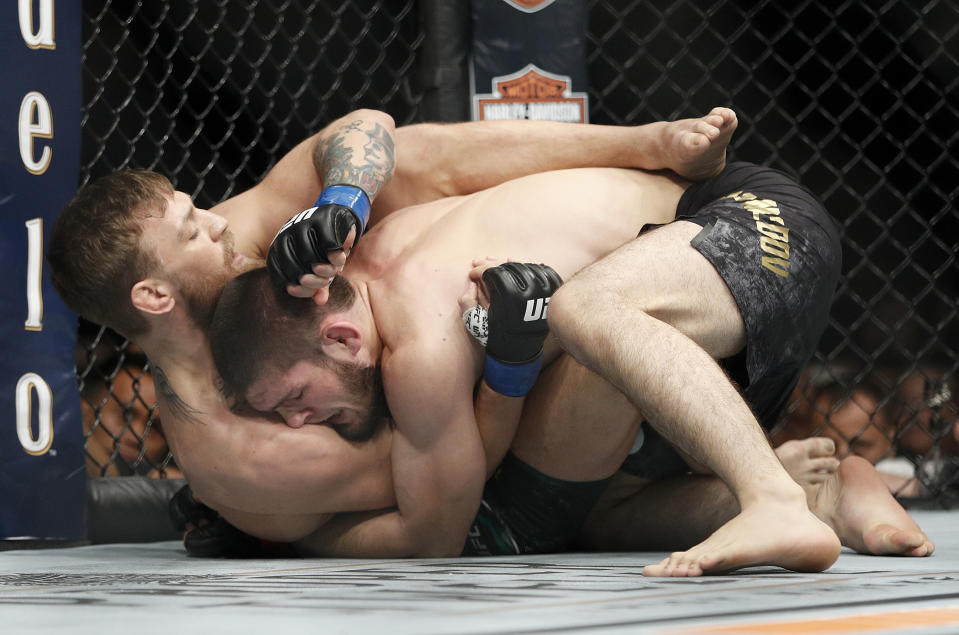 Conor McGregor, left, fights, Khabib Nurmagomedov during a lightweight title mixed martial arts bout at UFC 229 in Las Vegas, Saturday, Oct. 6, 2018. (AP Photo/John Locher)