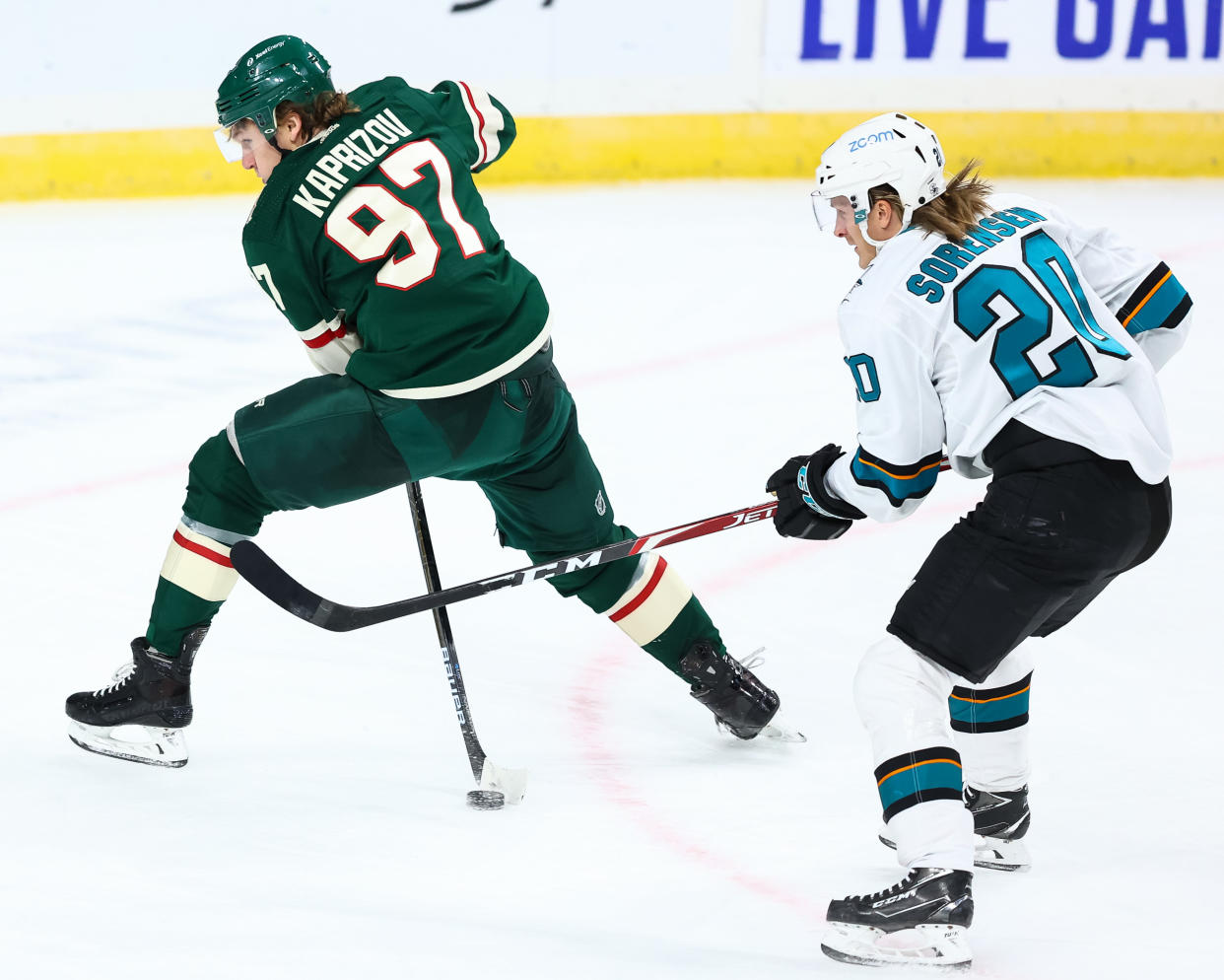 ST PAUL, MN - JANUARY 22: Kirill Kaprizov #97 of the Minnesota Wild attempts to pass the puck as Marcus Sorensen #20 of the San Jose Sharks defends him during the third period at Xcel Energy Center on January 22, 2021 in St Paul, Minnesota. (Photo by Harrison Barden/Getty Images)