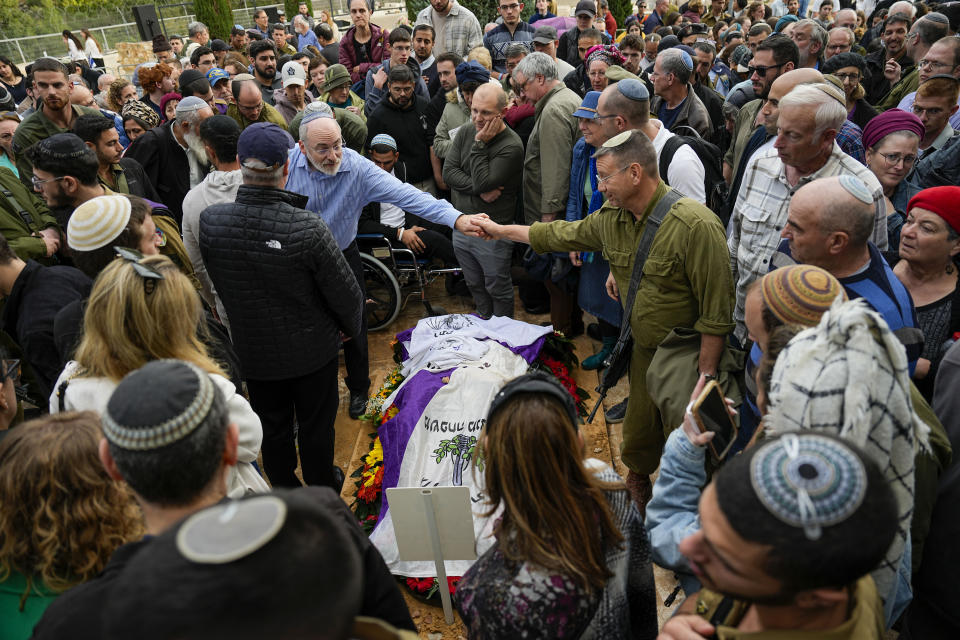 Mourners gather in grief around the grave of American-Israeli reserve solider Sergeant first class Amichai Yisrael Yehoshua Oster during his funeral in the West Bank settlement of Karnei Shomron Tuesday, Jan. 2, 2024. Oster, 24, was killed during the Israeli military's ground operation in the Gaza Strip while the army is battling Palestinian militants in the war ignited by Hamas' Oct. 7 attack into Israel.(AP Photo/Ariel Schalit)