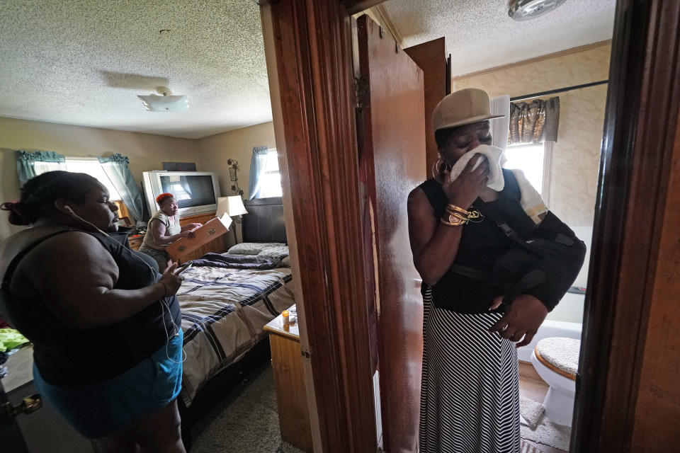 Rakisha Murray, right, reacts as she sees for the first time the damaged home of her sister, Patricia Mingo Lavergne, background, in Lake Charles, La., after they returned from evacuation in the aftermath of Hurricane Laura, Sunday, Aug. 30, 2020. (AP Photo/Gerald Herbert)