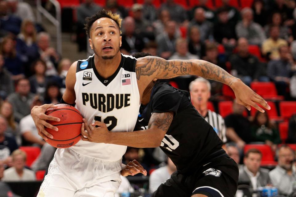 Purdue forward Vincent Edwards (12) looks to make a play defended by Butler guard Henry Baddley (20) in the second round of the 2018 NCAA Tournament at Little Caesars Arena.