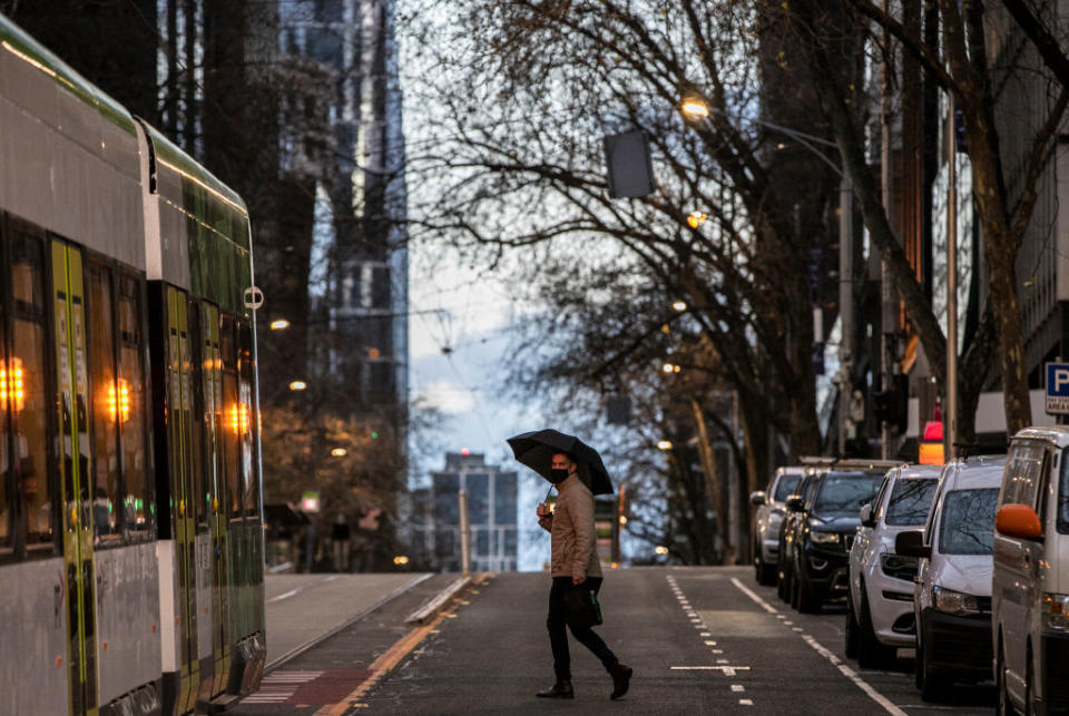 A man is seen wearing a face mask while crossing Bourke Street in Melbourne, Australia. 