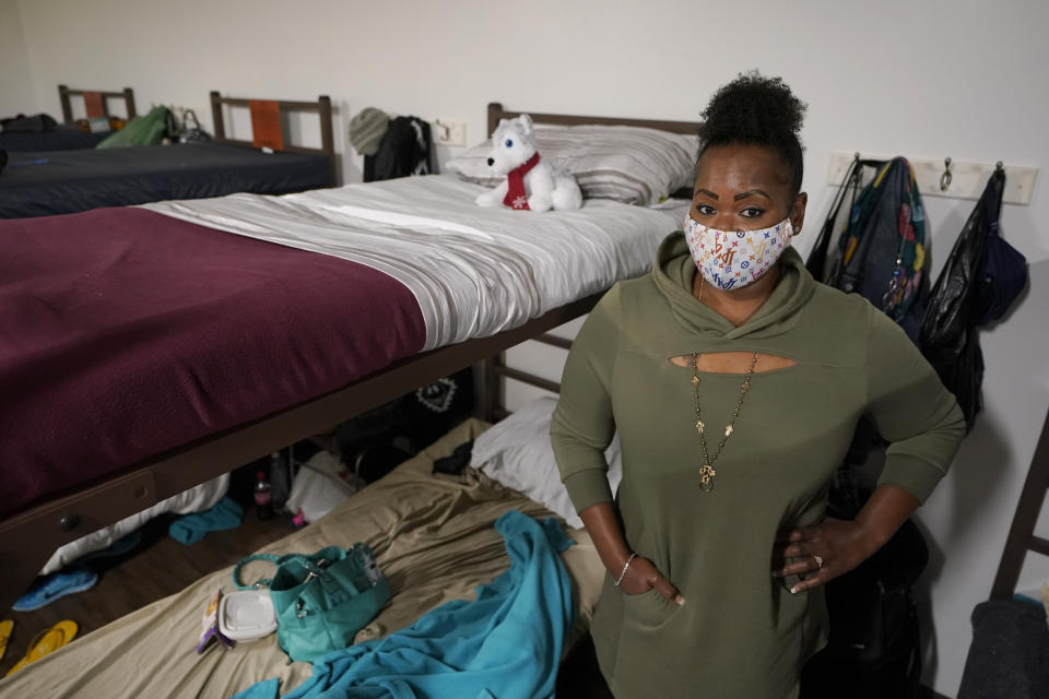 Cidney Oliver poses for a photo, Wednesday, April 7, 2021, by the bunk she sleeps on at a YWCA shelter for women lacking housing in Seattle. Earlier in the day, Oliver received the first dose of the Moderna COVID-19 vaccine at a clinic staffed by workers from Harborview Medical Center at the shelter. “It was important for me to protect myself and the health and welfare of others,” Oliver said. (AP Photo/Ted S. Warren)