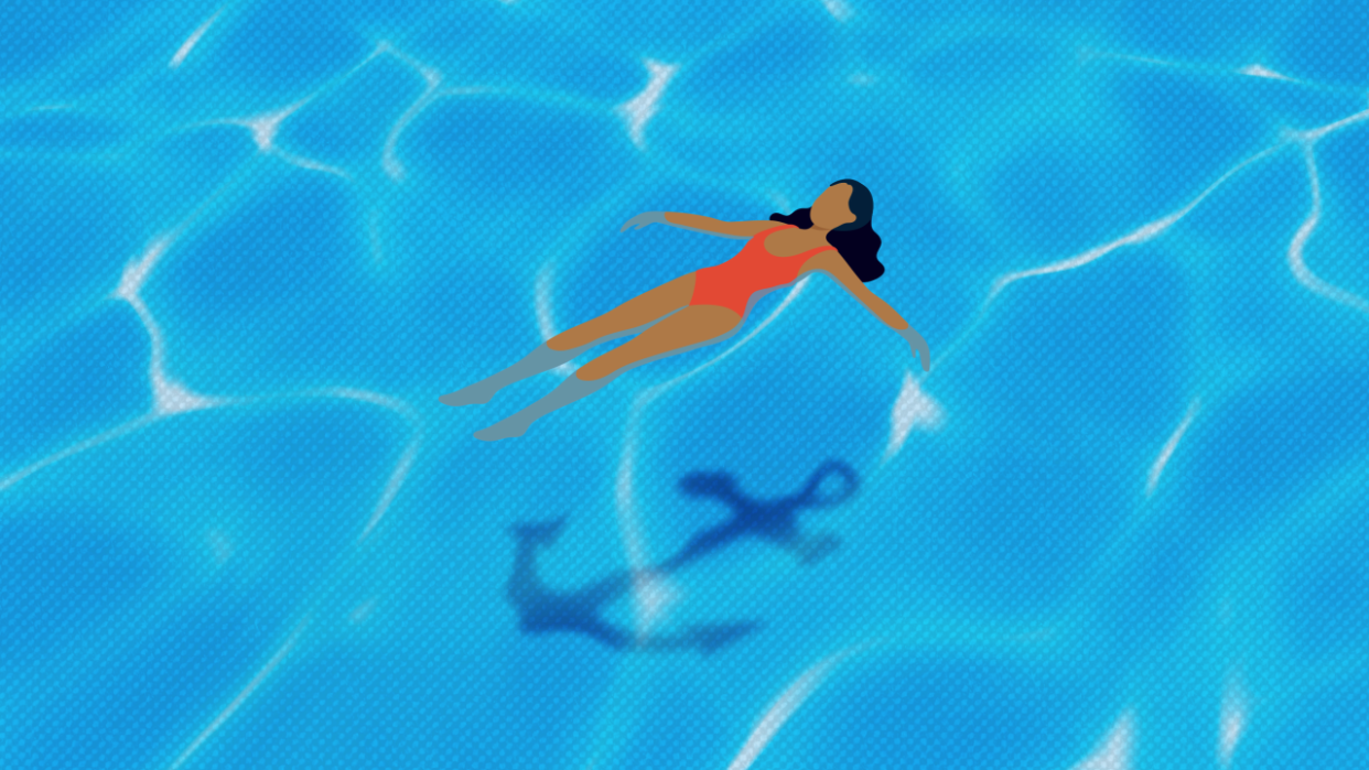 Woman floating in a pool above a reflection of an anchor
