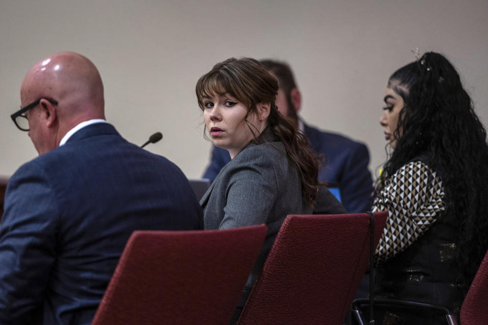 CORRECTS SOURCE TO ALBUQUERQUE JOURNAL INSTEAD OF SANTA FE NEW MEXICAN - Hannah Gutierrez-Reed, center, sits with her attorney Jason Bowles, left, during the first day of testimony in the trial against her in First District Court, in Santa Fe, N.M., Thursday, Feb. 22, 2024. Gutierrez-Reed, who was working as the armorer on the movie "Rust," when a revolver actor Alec Baldwin was holding fired and killed cinematographer Halyna Hutchins and wounded the film’s director, Joel Souza, is charged with involuntary manslaughter and tampering with evidence. (Eddie Moore/The Albuquerque Journal via AP, Pool)