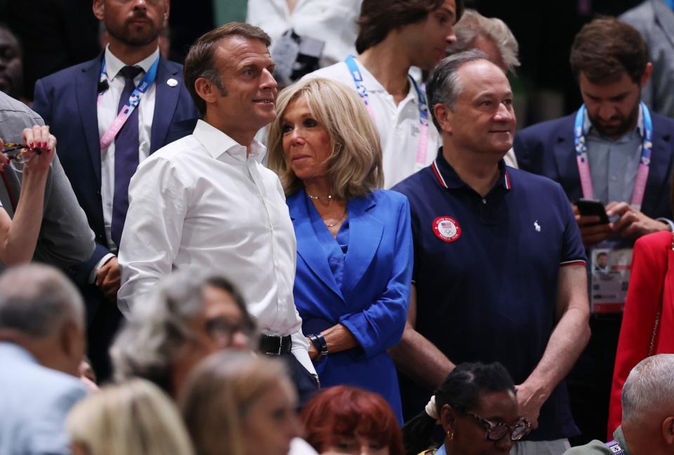 French President Emmanuel Macron, left, and Brigitte Macron in a sapphire blue suit, center, and Second Gentleman Douglas Emhoff, right, at the 2024 Paris Olympics on Aug. 11.