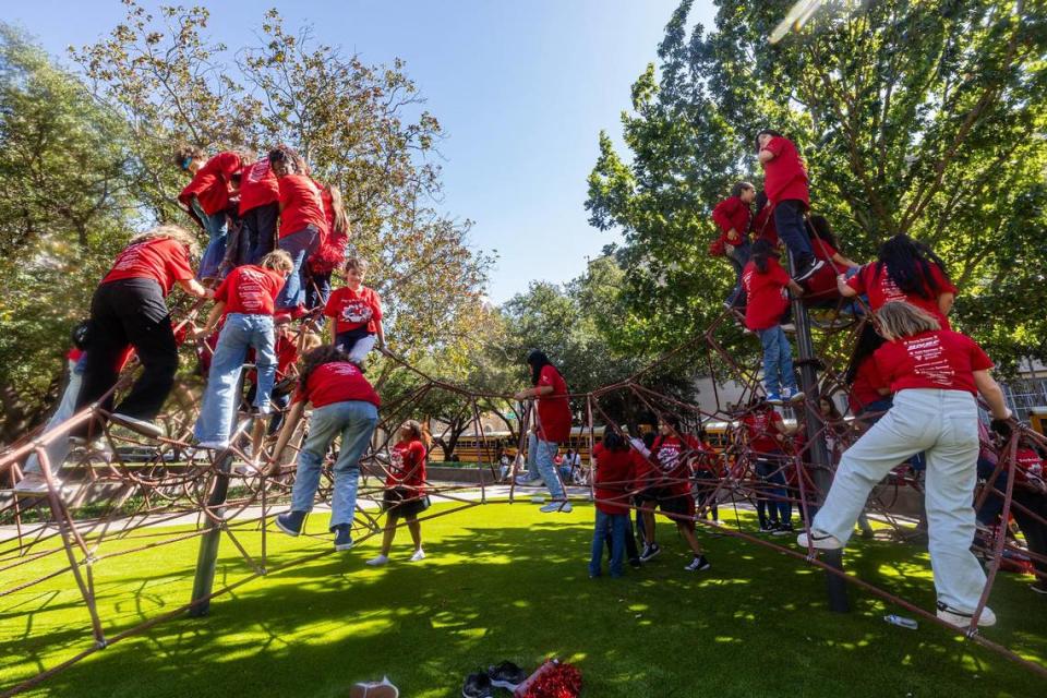 Members of the Girls Inc. of Tarrant County climb up the playground before 2023 Day of the Girl march event at Burnett Park in Fort Worth on Friday.