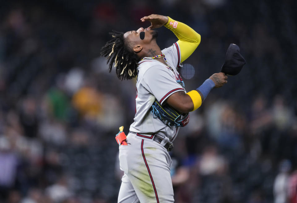 Atlanta Braves right fielder Ronald Acuña Jr. tips back his head before putting on his cap as he heads out to his position during the seventh inning of the team's baseball game against the Colorado Rockies on Wednesday, Aug. 30, 2023, in Denver. (AP Photo/David Zalubowski)