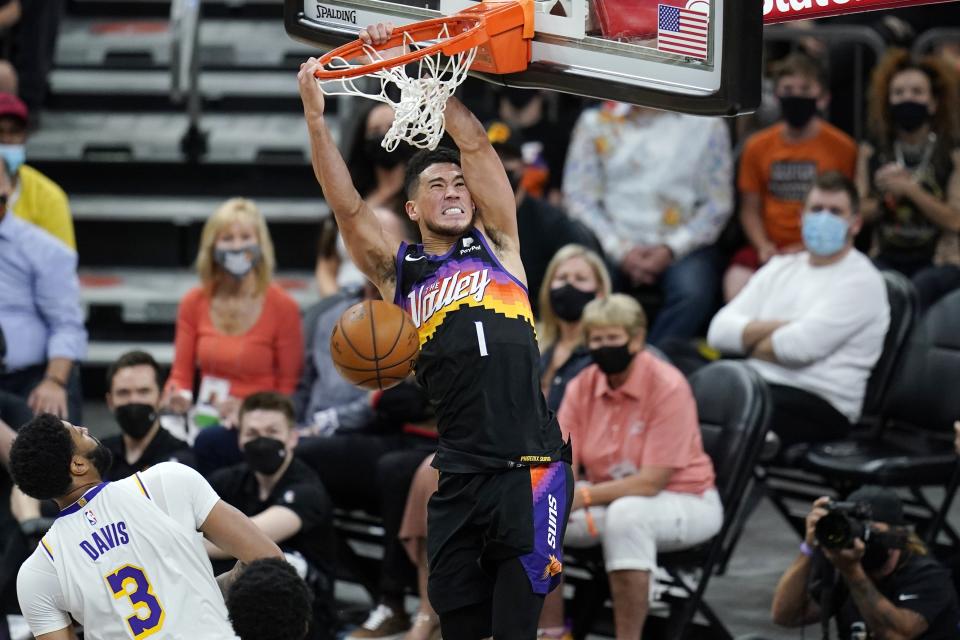 Phoenix Suns guard Devin Booker (1) dunks as he drives past Los Angeles Lakers forward Anthony Davis (3) in Game 1. (AP Photo/Ross D. Franklin)