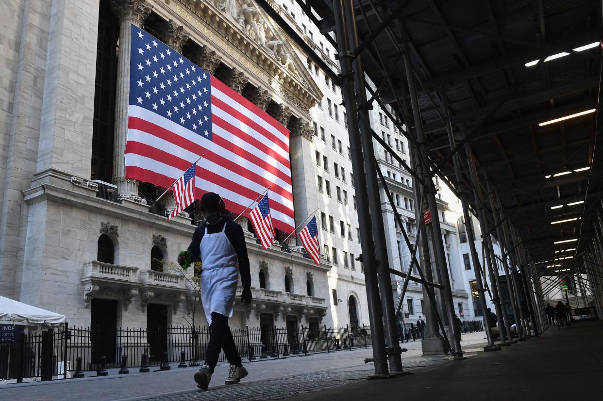 A person walks past the New York Stock Exchange (NYSE) at Wall Street on November 16, 2020 in New York City. - Wall Street stocks rose early following upbeat news on a coronavirus vaccine and merger announcements in the banking and retail industries. (Photo by Angela Weiss / AFP) (Photo by ANGELA WEISS/AFP via Getty Images)