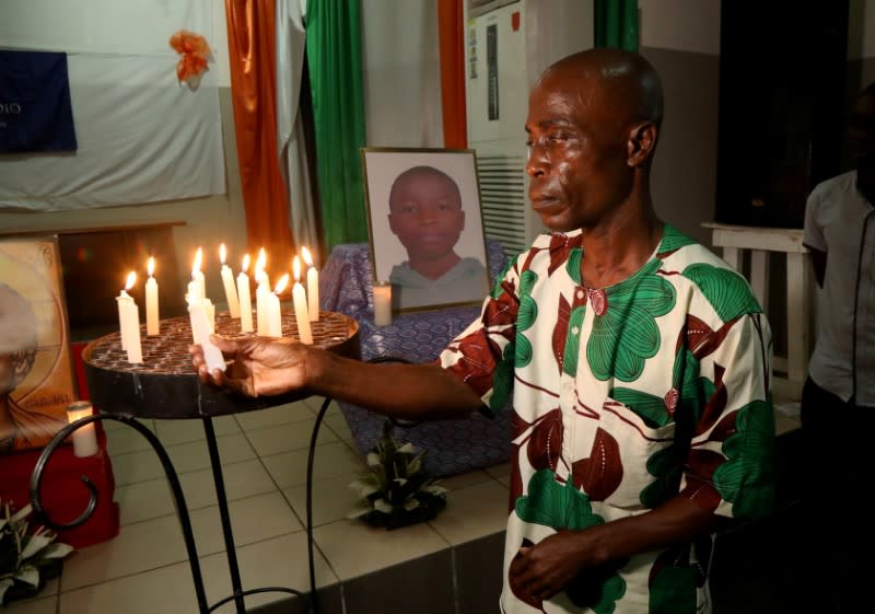 Marius Ani Oulakole, father of Barthelemy Laurent Guibahi Ani, a 14 years old boy who was found dead in the undercarriage of an Air France airplane, lights a candle during a tribute prayer to his son in Abidjan