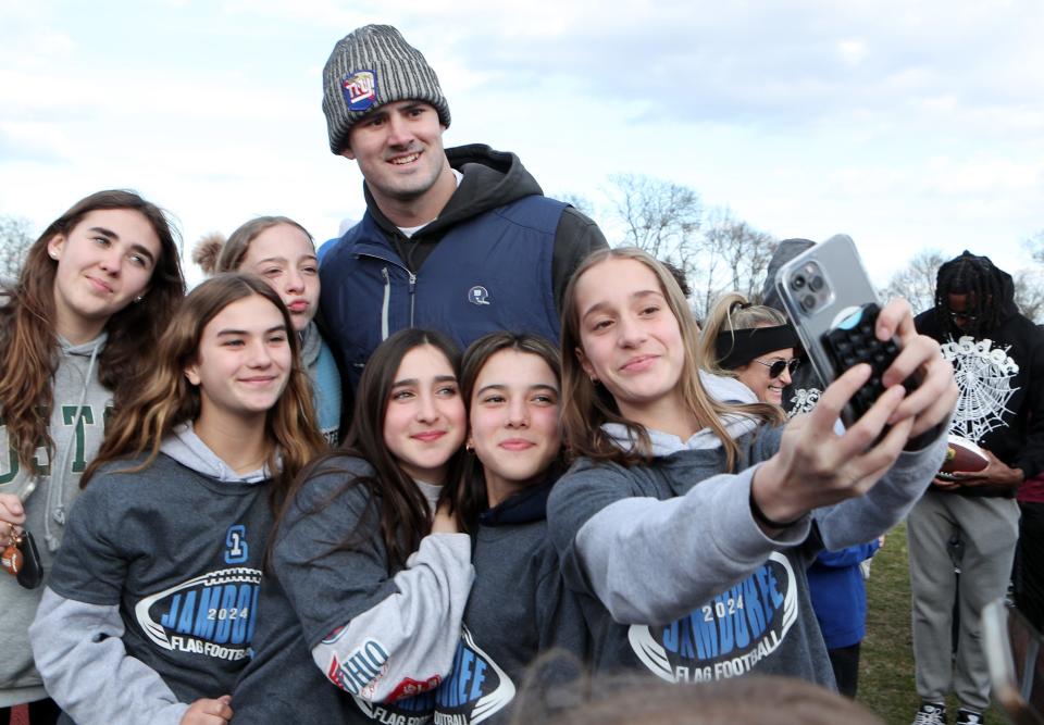 Giants quarterback Daniel Jones poses for photos with flag football athletes as the New York Giants and Section 1 hosted the third annual Section 1 Girls Flag Football Jamboree at Somers High School March 19. 2024.