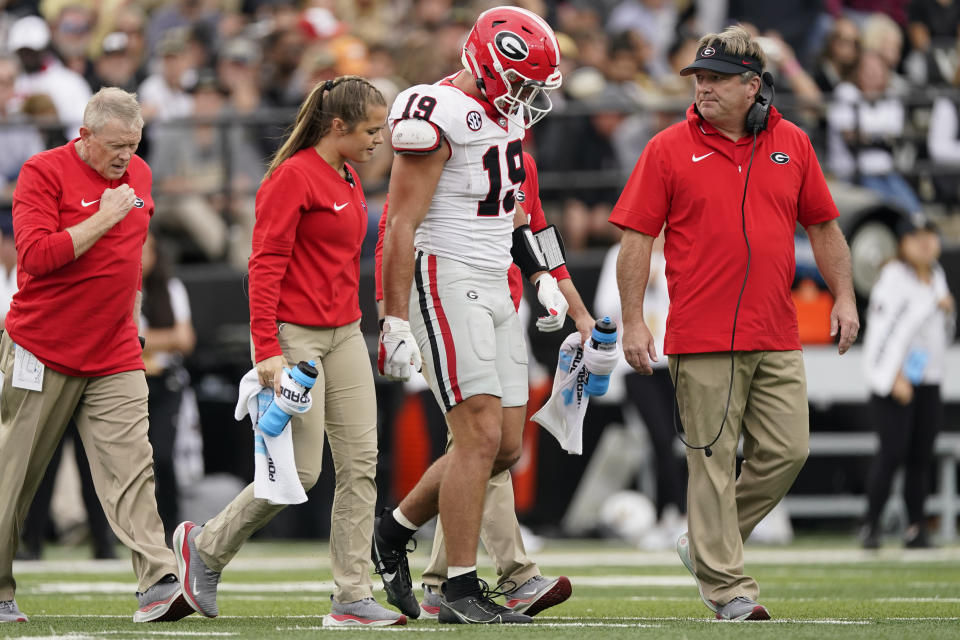 Georgia tight end Brock Bowers (19) walks off the field after being injured with head coach Kirby Smar, right, in the first half of an NCAA college football game Saturday, Oct. 14, 2023, in Nashville, Tenn. (AP Photo/George Walker IV)