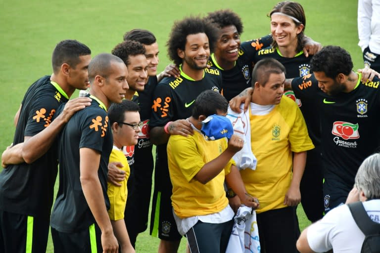 Brazil's footballers pose for photos with children on World Down Syndrome Day after a training session in Sao Paulo, on March 21, 2017, ahead of their FIFA World Cup South American qualifier matches against Uruguay and Paraguay