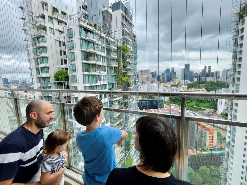 Israeli expatriate Atar Sandler and her husband speak to their children at the balcony of their apartment in central Singapore