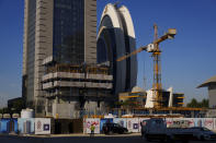 A crane operates on a construction cite with the Crescent Tower Lusail in the background in Lusail downtown, Qatar, Thursday, Nov. 24, 2022. (AP Photo/Pavel Golovkin)