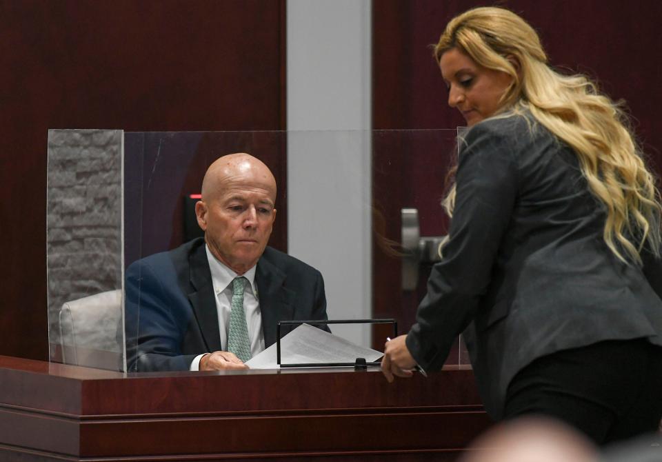 Monte Falls, city manager for the City of Vero Beach, is presented with evidence to study from Lauren Frieder, representing the Vero Beach Preservation Alliance, during a trial between VBPA and the CIty of Vero Beach on Friday, Nov. 4, 2022, in the Indian River County Courthouse in Vero Beach.