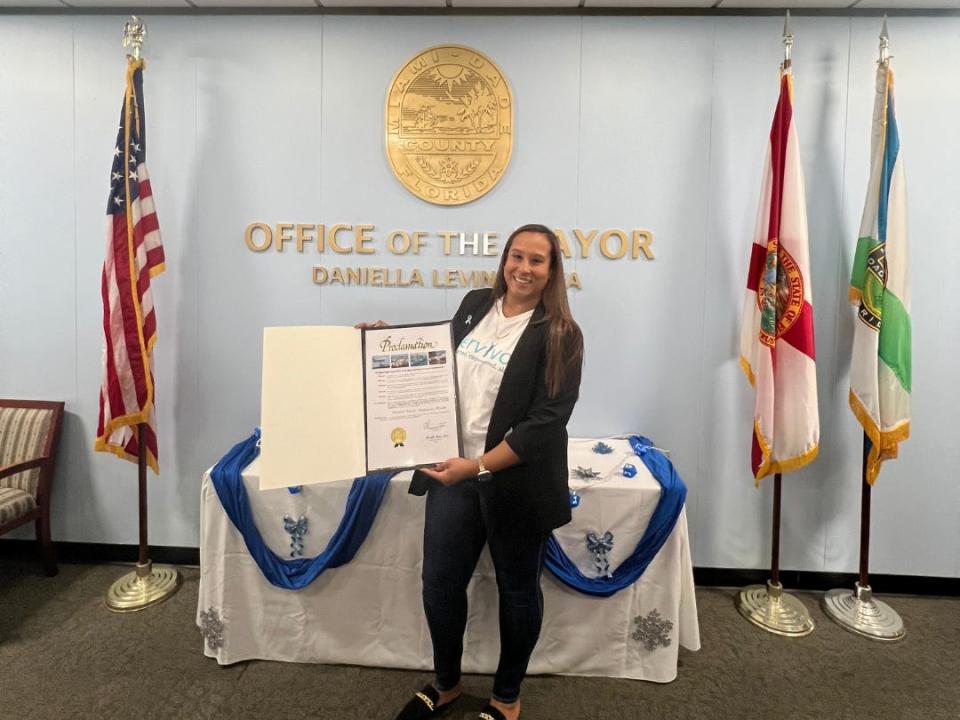 Avi Grant-Noonan holding a proclamation from the governor of Florida about January being Cervical Cancer Awareness Month.