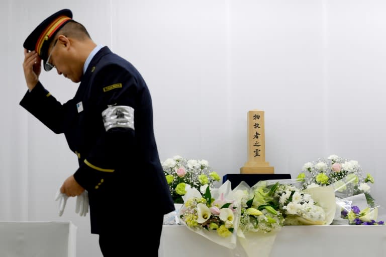 Train employees pay their respects at the site where passengers were overcome by sarin gas