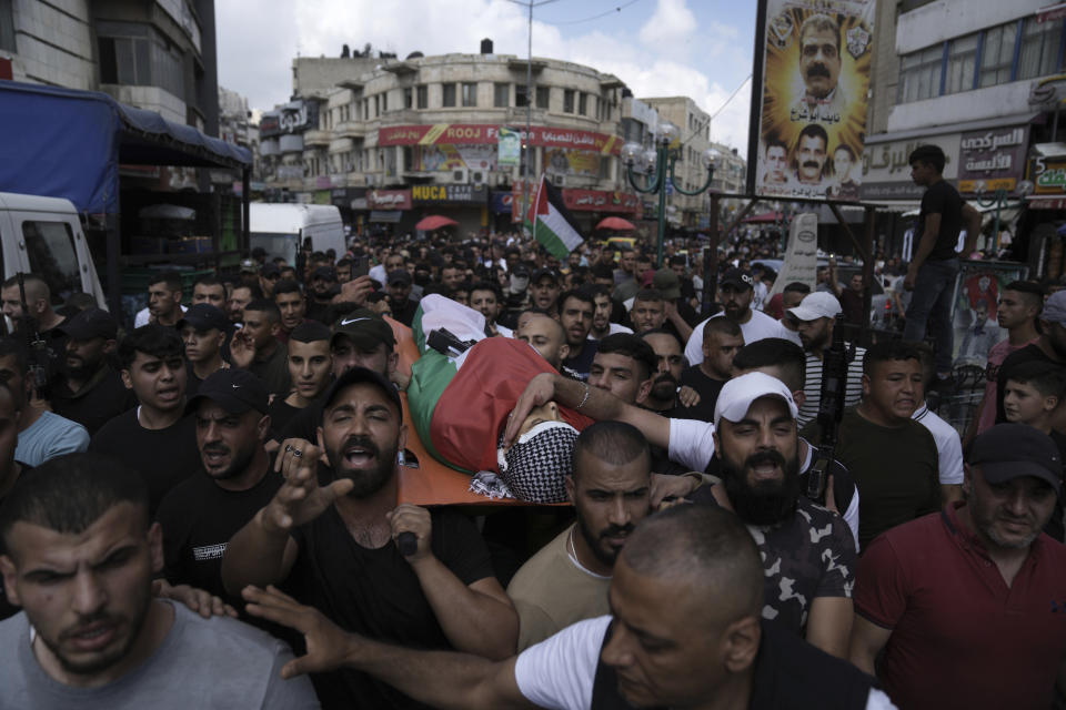 Palestinian mourners carry the body of Khalil Yahya Anis during his funeral in the West Bank city of Nablus, Thursday, June 15, 2023. The Palestinian Health Ministry said the 20-year-old man was shot in the head by Israeli forces. The Israeli military said troops operating in the city came under fire and fired back. (AP Photo/Nasser Nasser)