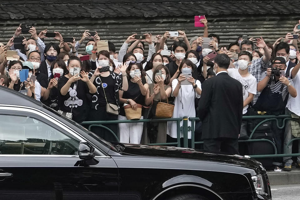 Bystanders on the street send off the hearse carrying the body of former Japanese Prime Minister Shinzo Abe as it leaves Zojoji temple after his funeral in Tokyo on Tuesday, July 12, 2022. Abe was assassinated Friday while campaigning in Nara, western Japan. (AP Photo/Hiro Komae)