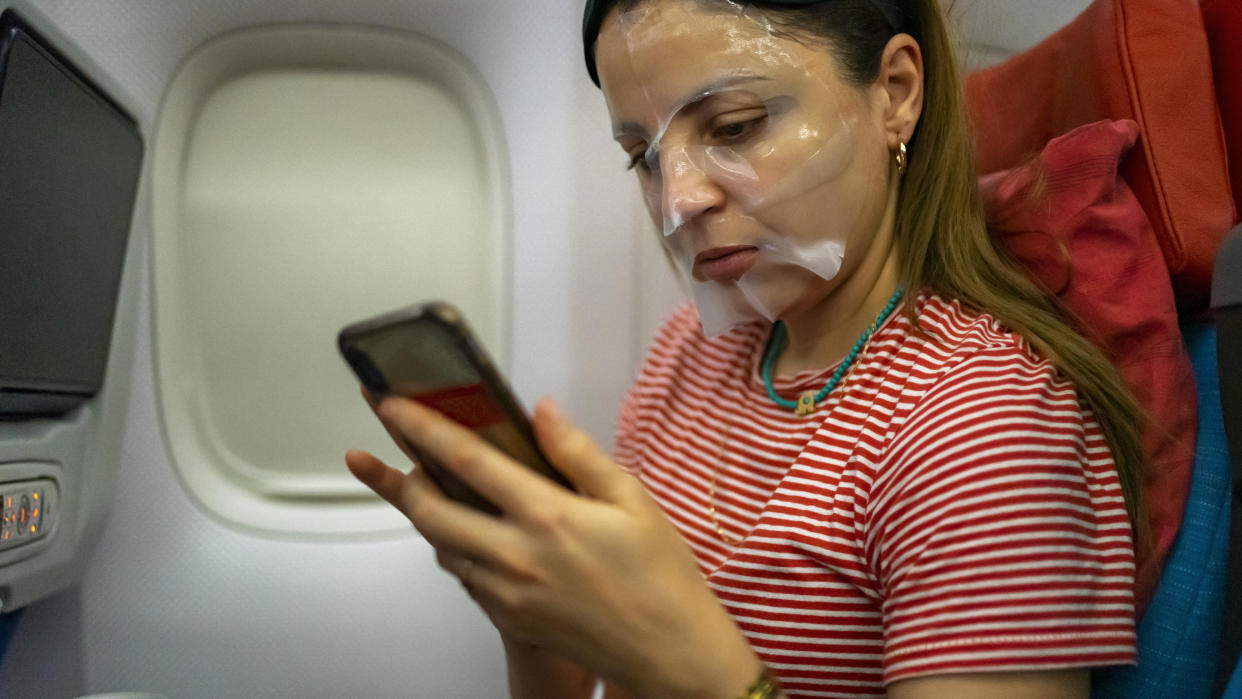 women use in sheet mask on the airplane