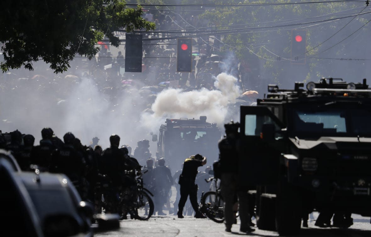 Smoke rises as police clash with protesters during a Black Lives Matter protest near the Seattle Police East Precinct headquarters on July 25, 2020, in Seattle. (AP Photo/Ted S. Warren, File)