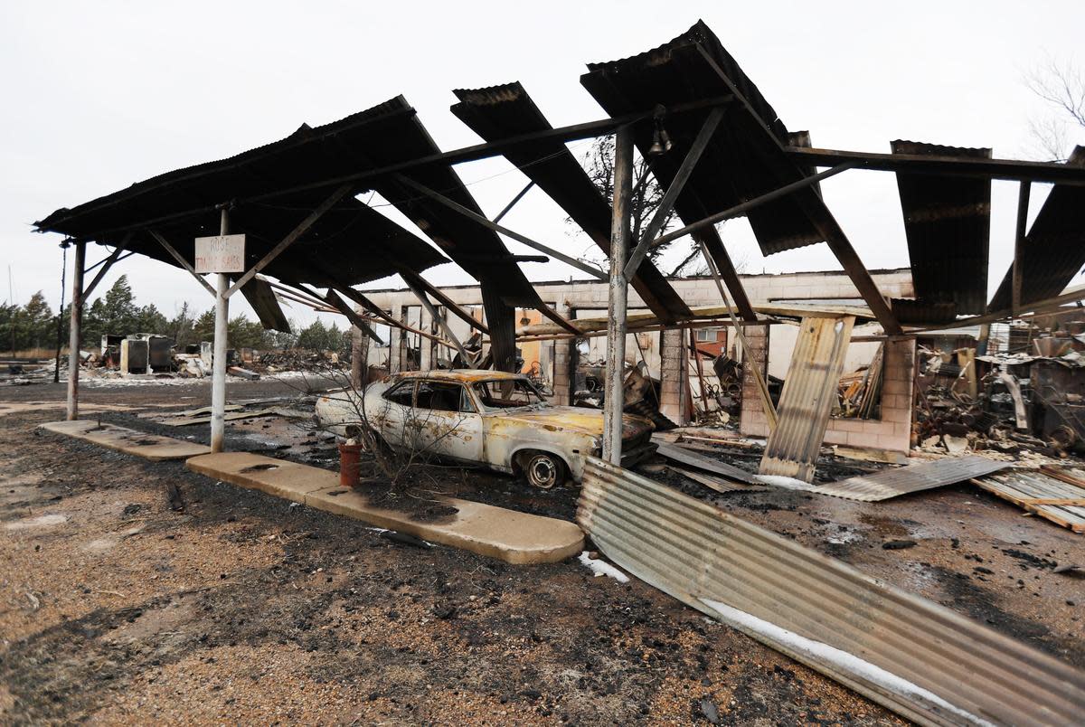 A car sits front of the burned the Rose Trailer Sales business on State Highway 136. Residents have been working to recover from the Tuesday grass fires that devastated parts of the panhandle.