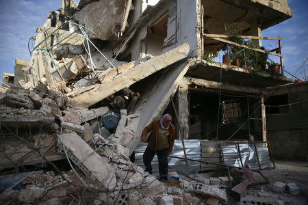 (Warning: graphic content) A person inspects damaged building in the besieged town of Douma, Eastern Ghouta, Damascus, February 20. REUTERS/Bassam Khabieh