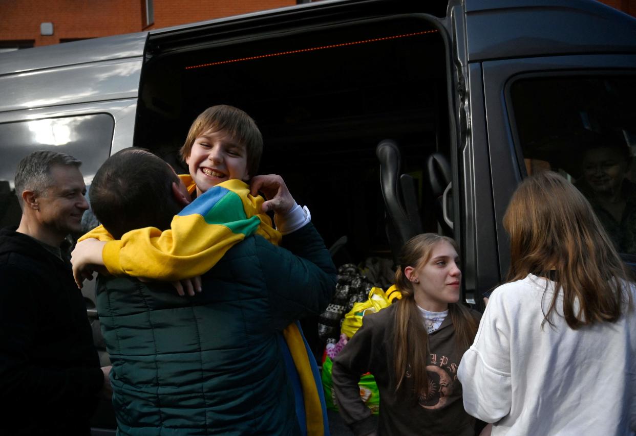 Denys Zaporozhchenko (left) meets his children Nikita, Yana and Dayana (right)  as they return to Kyiv from Russian-held territory (AFP/Getty)