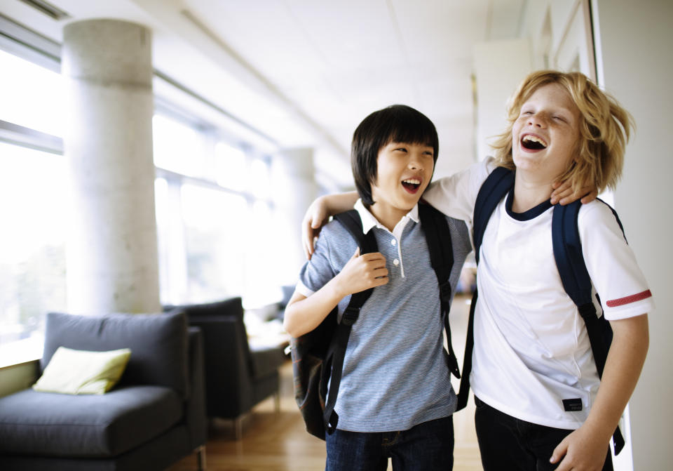 two boys laughing with arms around each other 