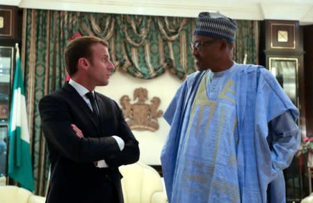 FILE PHOTO: French President Emmanuel Macron speaks with Nigeria's President Muhammadu Buhari at the Presidential State House in Abuja, Nigeria, July 3, 2018.   Ludovic Marin/Pool via Reuters