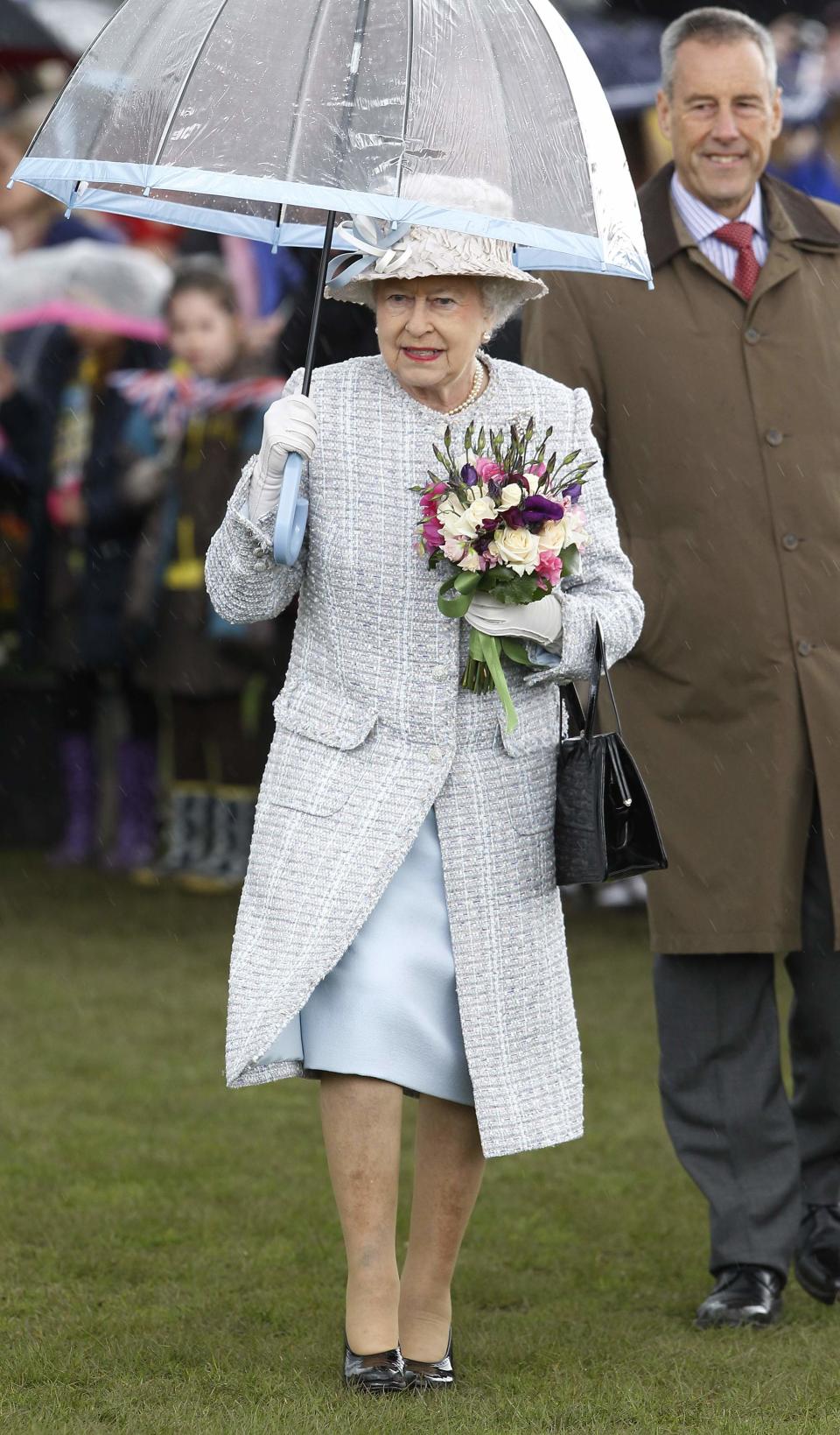 <p>Als es 2012 bei einer Ausstellung im Londoner Stadtbezirk Richmond anfing zu regnen, absolvierte die Queen den Termin kurzerhand mit Schirm. Dessen babyblauer Rand harmonierte, natürlich, ideal mit ihrem Kleid. (Bild: Getty Images) </p>