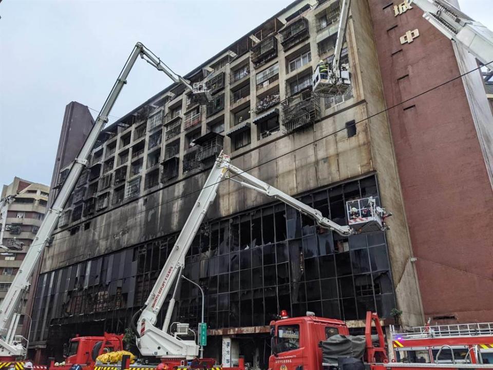 高雄城中城14日凌晨發生大火，消防人員利用雲梯車搶救生還住戶。（曹明正攝）