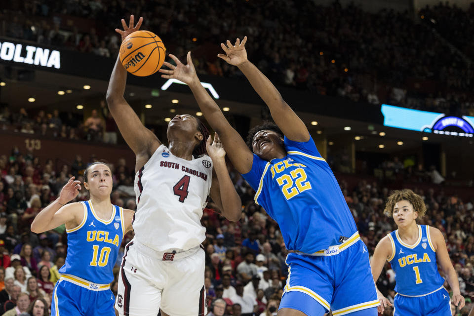 South Carolina's Aliyah Boston (4) fights for a rebound over UCLA's Christeen Iwuala (22) and Gina Conti (10) in the first half of a Sweet 16 college basketball game at the NCAA Tournament in Greenville, S.C., Saturday, March 25, 2023. (AP Photo/Mic Smith)