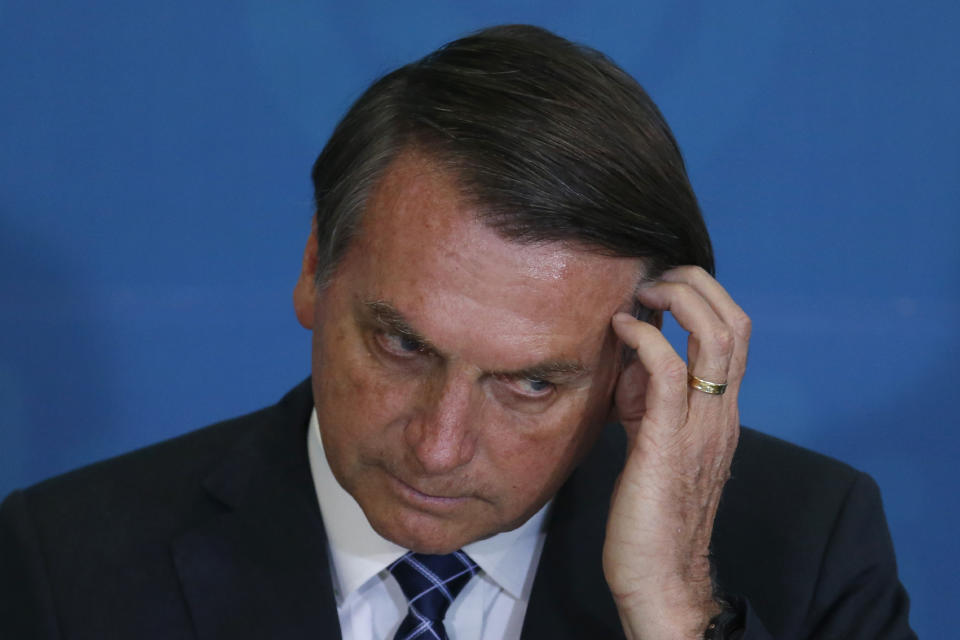 El presidente de Brasil Jair Bolsonaro se rasca la frente durante una ceremonia en el palacio presidencial Planalto en Brasilia, Brasil, el lunes 2 de diciembre de 2019. (AP Foto /Eraldo Peres)