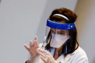 A medical worker prepares a syringe with a dose of the Johnson & Johnson coronavirus disease (COVID-19) vaccine during a visit of U.S. Vice President Kamala Harris to a vaccination center in Chinatown, in Chicago