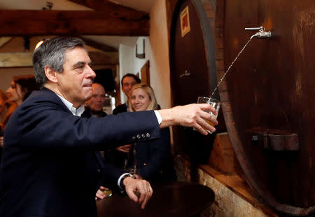 Francois Fillon, former French Prime Minister, member of the Republicans political party and 2017 presidential election candidate of the French centre-right serves a glass of Cider as he campaigns in Arbonne, France March 25, 2017. REUTERS/Regis Duvignau